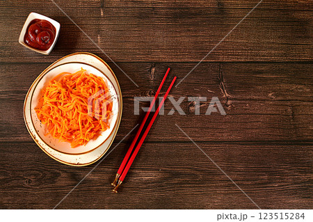 Korean kimchi side dish for barbecue dinner, carrot with sauce and hot pepper, set of fermented foods good for gut health. Carrot, cabbage, garlic, parsley and juice on wooden background, healthy 123515284