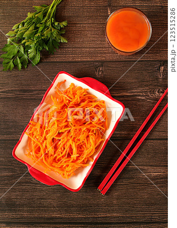Korean kimchi side dish for barbecue dinner, carrot with sauce and hot pepper, set of fermented foods good for gut health. Carrot, cabbage, garlic, parsley and juice on wooden background, healthy Korean kimchi side dish for barbecue dinner, carrot with sauce and hot pepper, set of fermented foods good for gut health. Carrot, cabbage, garlic, parsley and juice on wooden background, healthy 123515286