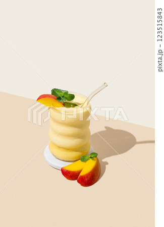 Vegetarian smoothie with mango and banana in a glass on a yellow background with shadow. 123515843