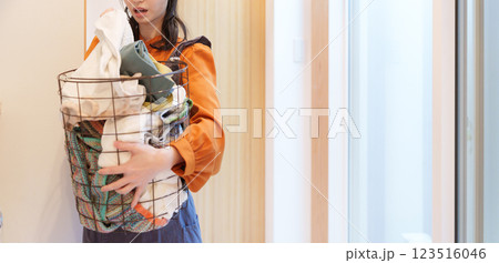 臭い洗濯物の臭いを嗅いで鼻をつまむ女性 123516046