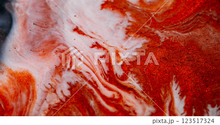 Marble flow. Sparkling ink. Defocused colorful shiny dust polish particles blend abstract background. Orange copper white liquid pigment pour. 123517324