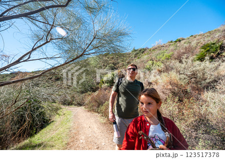 Father and daughter hiking in sunny countryside landscape 123517378