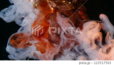 Fume explosion. Paint mix. Glitter orange matte white art fluid streams. Copper cloudy ink spray on black background broken light bulb. Fume explosion. Paint mix. Glitter orange matte white art fluid streams. Copper cloudy ink spray on black background broken light bulb. 123517503