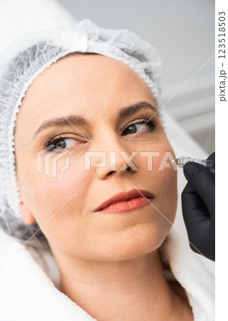 Woman receiving cosmetic treatment in a spa setting with a professional Woman receiving cosmetic treatment in a spa setting with a professional 123518503