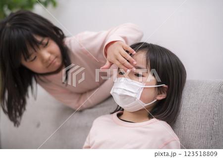 熱がある妹を心配する姉 123518809