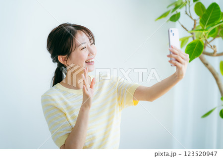 部屋でスマホを操作する女性 123520947