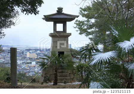 冬の琴弾山、石造の高灯籠から財田川河口の観音寺市旧市街を見る 123521115