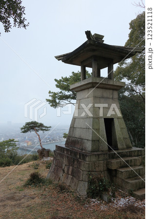 冬の琴弾山、石造の高灯籠から財田川河口の観音寺市旧市街を見る 123521118