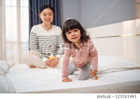 happy toddler baby girl with her mother on bed happy toddler baby girl with her mother on bed 123521465