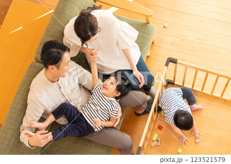 リビングで遊ぶ子供と若い夫婦 123521579