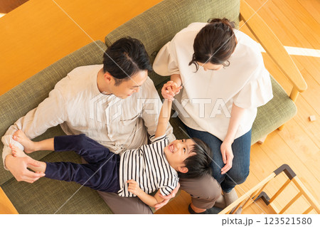 リビングで遊ぶ子供と若い夫婦 123521580