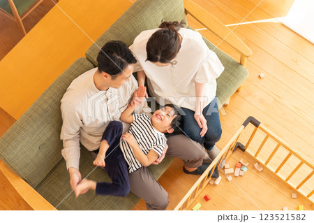 リビングで遊ぶ子供と若い夫婦 123521582