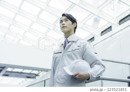 ヘルメットを持って立つ若い男性作業員　撮影協力:スカパー東京メディアセンター 123521851