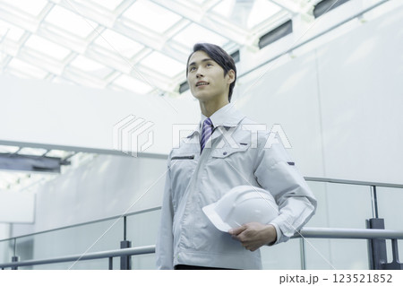 ヘルメットを持って立つ若い男性作業員　撮影協力:スカパー東京メディアセンター 123521852