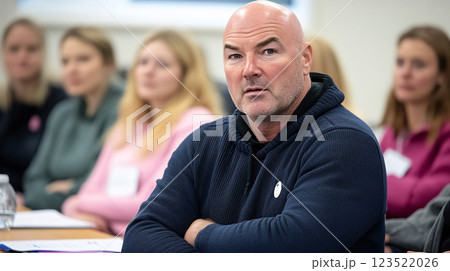 Intense Focused Man in Cozy Sweater Surrounded by Engaged Audience 123522026