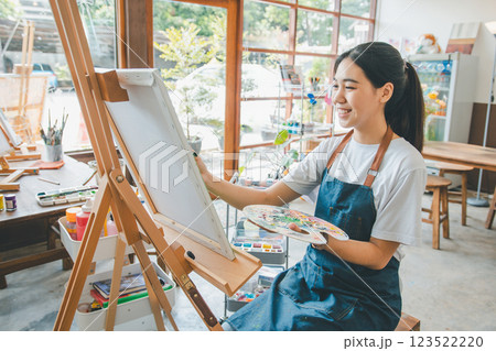 Art student drawing with watercolor painting on canvas doing some art projects on studio workshop 123522220