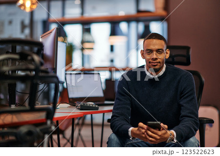 After Hours Reflection: African American Man Using Smartphone in Office. After Hours Reflection: African American Man Using Smartphone in Office. 123522623