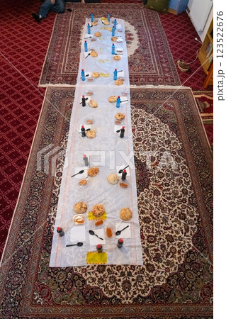 Top view of people serving food at a Mosque a communal meal during Ramadan before breaking the fast on Iftar dinner. Warm festive atmosphere celebrating Ramadan Karim and Eid, the Islamic holy month 123522676