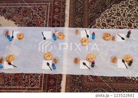 Top view of people serving food at a Mosque a communal meal during Ramadan before breaking the fast on Iftar dinner. Warm festive atmosphere celebrating Ramadan Karim and Eid, the Islamic holy month Top view of people serving food at a Mosque a communal meal during Ramadan before breaking the fast on Iftar dinner. Warm festive atmosphere celebrating Ramadan Karim and Eid, the Islamic holy month 123522681