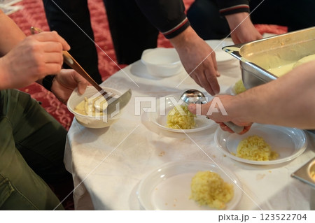Top view of people serving food at a Mosque a communal meal during Ramadan before breaking the fast on Iftar dinner. Warm festive atmosphere celebrating Ramadan Karim and Eid, the Islamic holy month 123522704