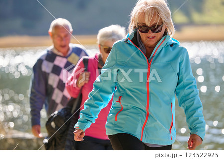 A family shares delightful moments with their friends amid the stunning landscapes of mountains, lakes, and winding paths, promoting a healthy lifestyle and the joy of familial bonds in the embrace of 123522925