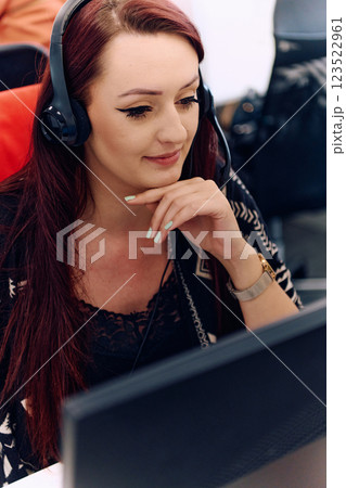 Friendly Call Center Agent Answering Incoming Calls with Headset Providing Remote Customer Service. 123522961