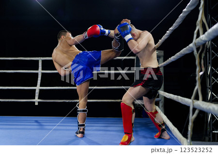 Kickboxing rivals unleash powerful leg strikes in a thrilling match. 123523252