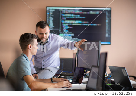 Programmers engrossed in deep collaboration, diligently working together to solve complex problems  123523255