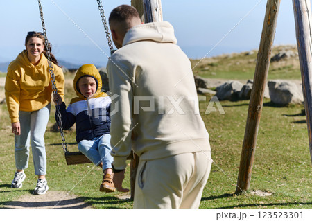 A modern family, along with their son, revels in the joy of a muddy day in nature, running and playing together, encapsulating the beauty of a healthy and active lifestyle 123523301