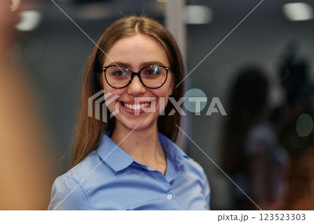 Confident Businesswoman in Glasses and Blue Shirt Engaged in Office Discussion 123523303