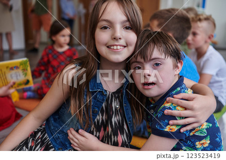 A girl and a boy with Down's syndrome in each other's arms spend time together in a preschool institution A girl and a boy with Down's syndrome in each other's arms spend time together in a preschool institution 123523419