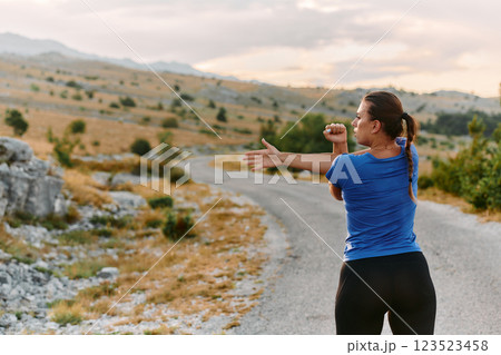 Determined Female Athlete Stretching After an Intense Run Through Rugged Mountain Terrain. Determined Female Athlete Stretching After an Intense Run Through Rugged Mountain Terrain. 123523458