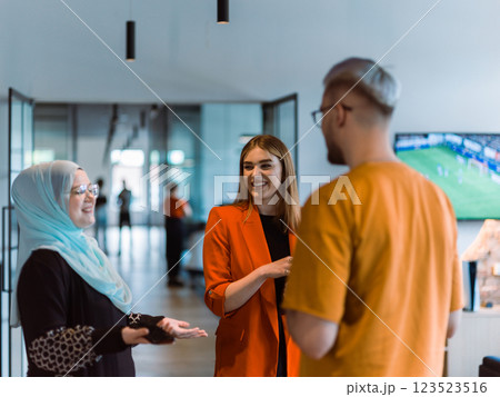 A group of young business colleagues, including a woman in a hijab, stands united in the modern corridor of a spacious startup coworking center, representing diversity and collaborative spirit A group of young business colleagues, including a woman in a hijab, stands united in the modern corridor of a spacious startup coworking center, representing diversity and collaborative spirit 123523516