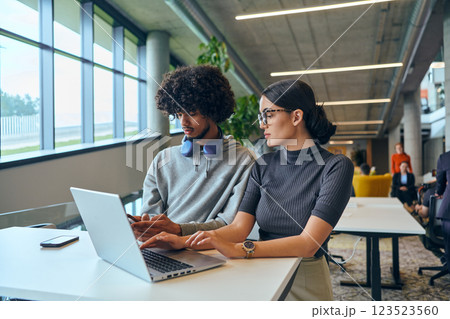 In a contemporary corporate setting, a diverse team of young business experts, including an African American man, collaboratively tackles business challenges with their colleagues embodying innovation 123523560