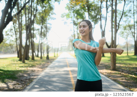 Fit young woman stretching before a workout in a scenic park 123523567