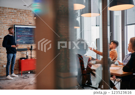 African-American businessman leads a meeting, passionately presenting a business plan to his attentive team, fostering collaboration and strategic thinking 123523616