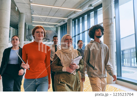 In the sleek corridors of a modern startup office, a diverse group of colleagues, led by their director, confidently stride forward, symbolizing collective success and the journey toward new business 123523704