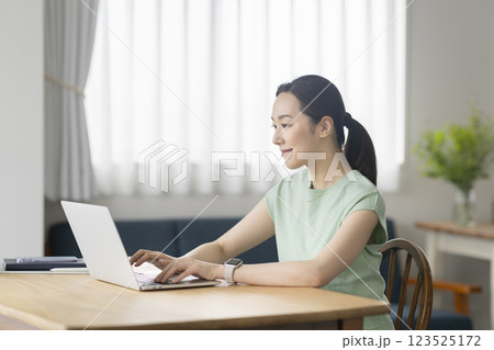 ノートパソコンで作業をする30代の女性　リモートワーク　在宅勤務　イメージ 123525172