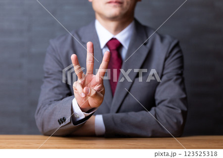 グレーのスーツを着て指を3本立てるミドル男性ビジネスマン グレーのスーツを着て指を3本立てるミドル男性ビジネスマン 123525318