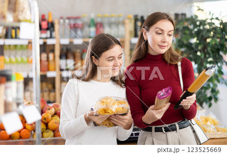 Mother and daughter choose pasta and spaghetti Mother and daughter choose pasta and spaghetti 123525669
