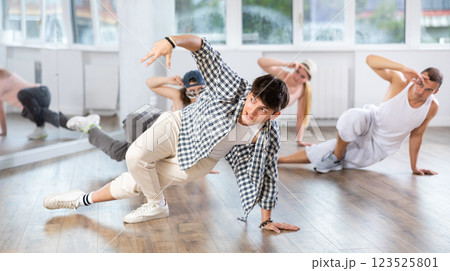 Young guy practicing breakdance floor-works in training hall 123525801