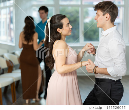 Latin American guy and dark-haired girl performing kizomba in dance studio 123526055