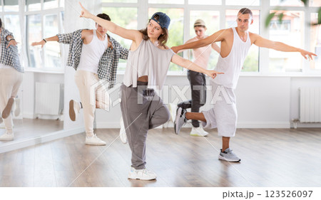 Young girl practicing kicking move of hip hop in training hall Young girl practicing kicking move of hip hop in training hall 123526097