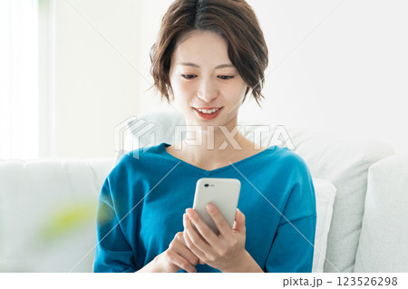 寝転んでスマホを見る若い女性 123526298