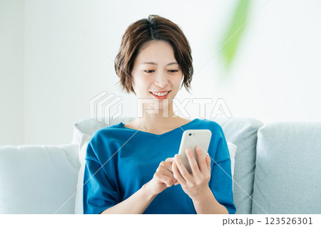 寝転んでスマホを見る若い女性 123526301