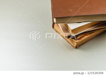 Stacked vintage books resting on a neutral background 123526309