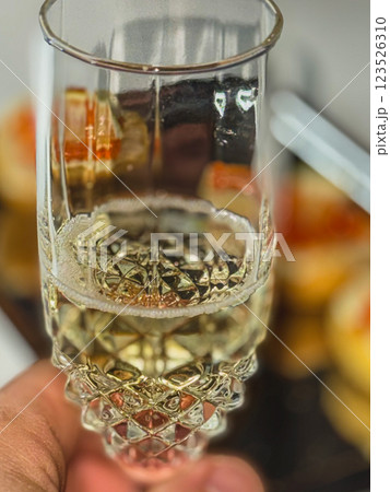 Celebrating with sparkling wine in a decorated glass at a festive gathering 123526310