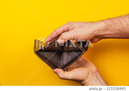Struggling businessman examines empty wallet amid financial crisis and despair 123526445