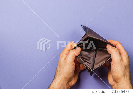 Struggling businessman examines empty wallet amidst financial crisis 123526478
