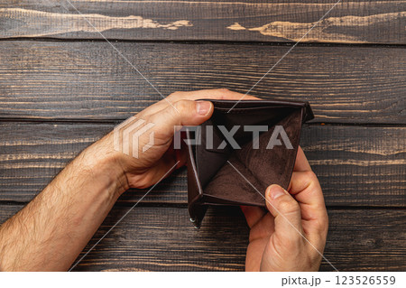 Broke businessman examines empty wallet in a moment of financial despair Broke businessman examines empty wallet in a moment of financial despair 123526559